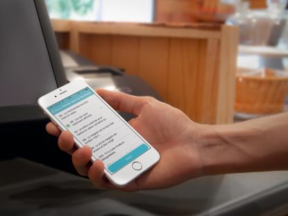 Photographie d'une main tenant un smartphone qui affiche l'application mobile Smice