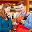 Photographie d'un sommelier qui conseille une bouteille de vin à une cliente